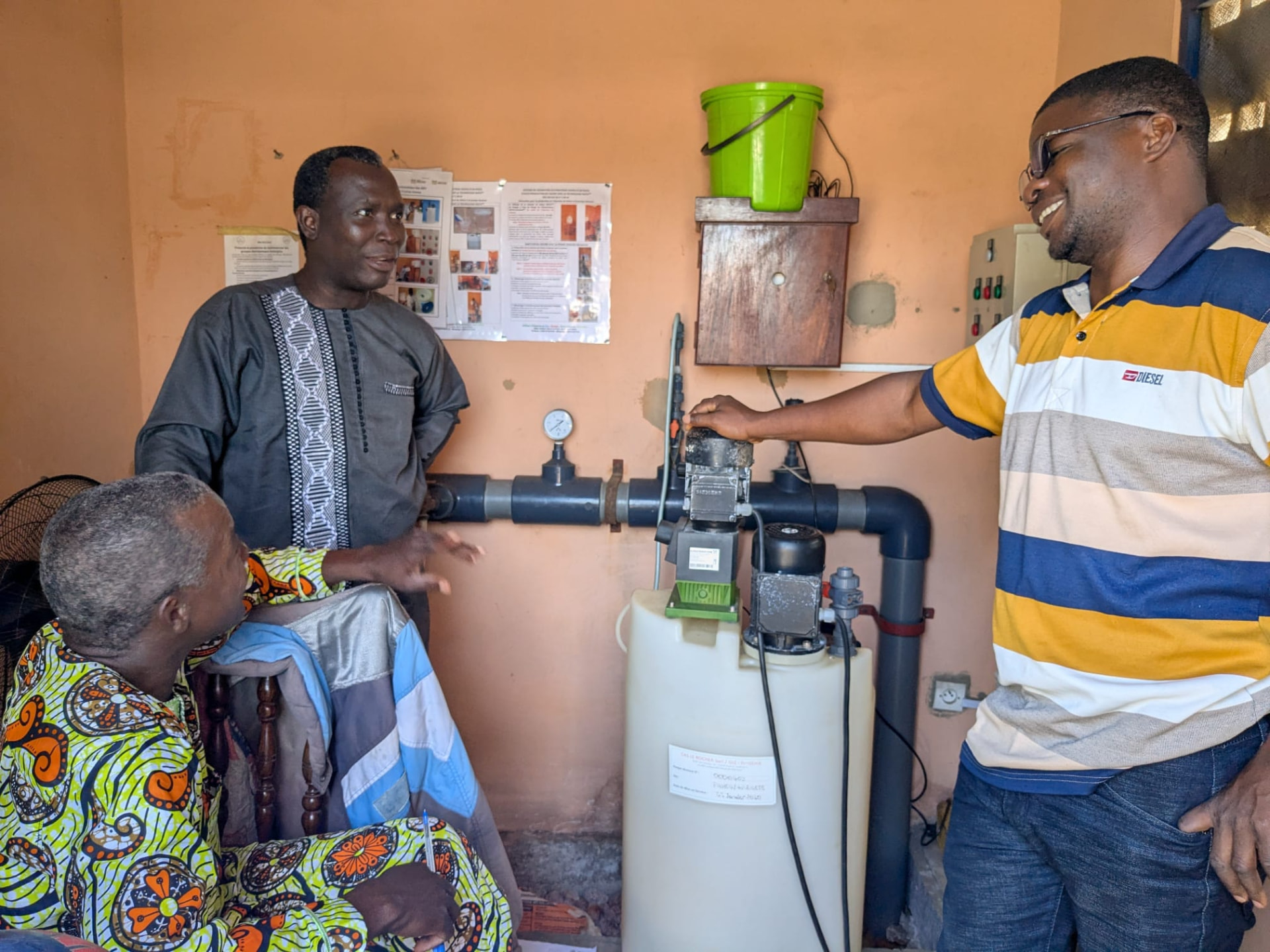 Technical field visit at a village water supply, reviewing the WATA dosing pump installation with local operators